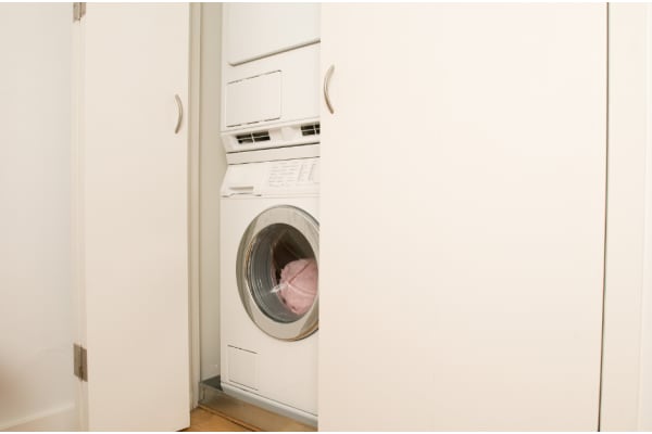 a white washer and dryer in a white closet